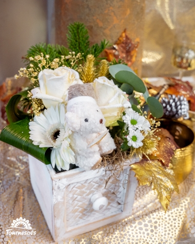 Composition florale du Nouvel An en blanc et or avec roses, gerbera et ourson décoratif.